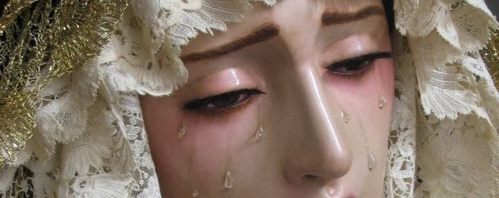 Beso la cara de una estatua de la Virgen María,